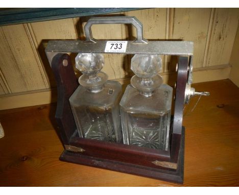 A two bottle lockable tantalus with key.