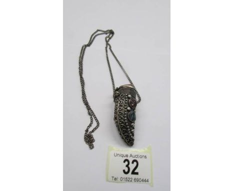 An old white metal pill box on chain set coloured stones.