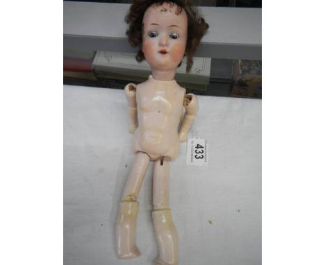 A 19c German porcelain headed doll with composition body