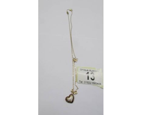 A 14k gold white &amp; black diamond heart pendant on a 14k chain, 3.26 grams.