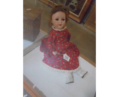 A 19th century German porcelain headed doll with composition body.