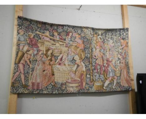 A wall hanging tapestry featuring a Medieval wine making scene, 200 x 70 cm.