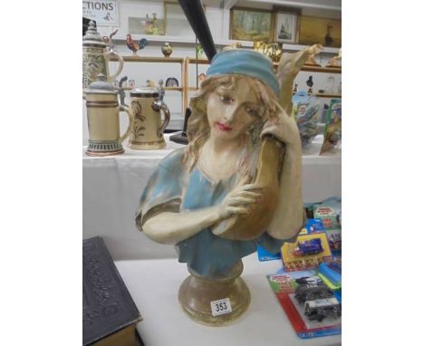 A classical style ceramic bust of a young lady with a string instrument.