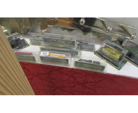 A quantity of 'N' gauge display model trains and military vehicles, some in sealed packages.