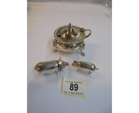 A silver plate pig matchbox with striker, a smaller example and a silver plate mustard pot.