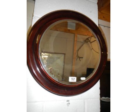 A metal framed circular bevel-edged mirror.