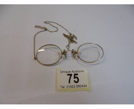 A pair of yellow metal pince nez on chain.