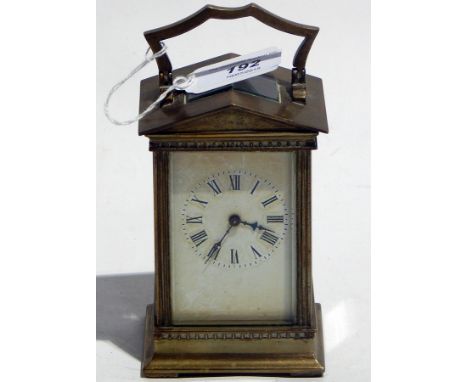Brass carriage clock with shaped hinged handle above arched pediment over dentil cornice to fluted pilasters and swept base, 