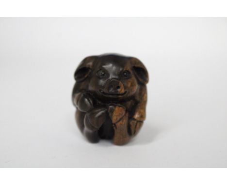 A CARVED PIG NETSUKE 
