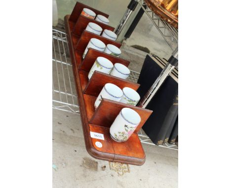 A WOODEN WALL HANGING DISPLAY STAND WITH ORIENTAL CERAMIC BEAKERS 