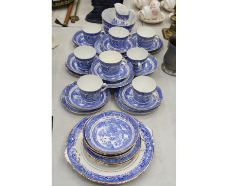 A QUANTITY OF ANTIQUE BLUE WILLOW WITH GOLD TRIM TO INCLUDE SLOP BOWL, MILK JUG, CUPS, SAUCERS, SIDE PLATES, CAKE/BREAD AND B