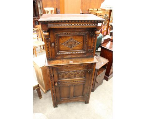AN OAK COCKTAIL CABINET IN THE FORM OF A COURT CUPBOARD BEARING RACKSTRAW (WORCESTER) LABEL, ENCLOSING TWO CUPBOARDS AND A SL