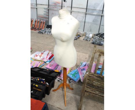 A DRESS MAKERS MANNEQUIN ON A WOODEN STAND 