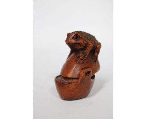 A CARVED WOODEN FROG NETSUKE, SIGNED TO THE BASE 