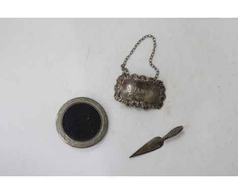 THREE HALLMARKED SILVER ITEMS TO INCLUDE A BRANDY DECANTER LABLE, MINIATURE ROUND PHOTOFRAME AND A TROWEL BOOKMARK - GROSS WE