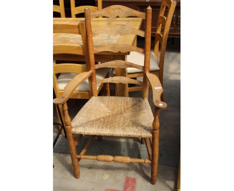 A GEORGE III STYLE OAK LADDER BACK ELBOW CHAIR WITH  RUSH SEAT 