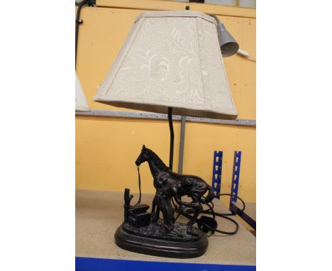A TABLE LAMP WITH A BLACKSMITH SHOEING A HORSE TO THE BASE, WITH SHADE 