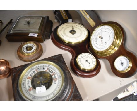 Five vintage barometers including an Edwardian example having carved oak frame with an enamel dial.