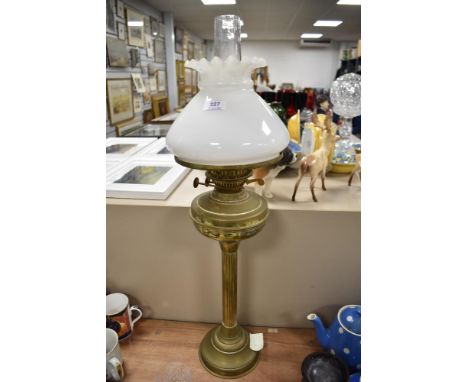 A Victorian oil burning lamp with a brass Roman style column base with milk glass light shade.