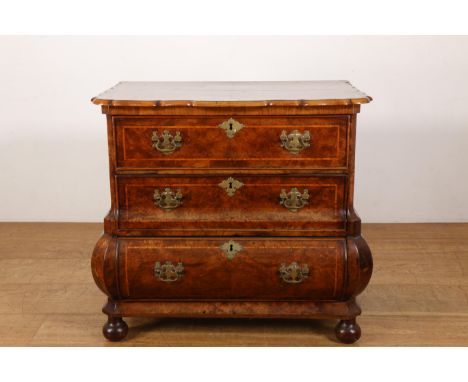 Notenwortelhouten commode, 18e eeuw, met in het gebogen front drie laden. Het geheel versierd met fijnhouten bieswerk en mess