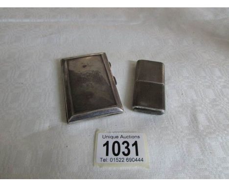 A silver cigarette lighter and a silver cigarette case