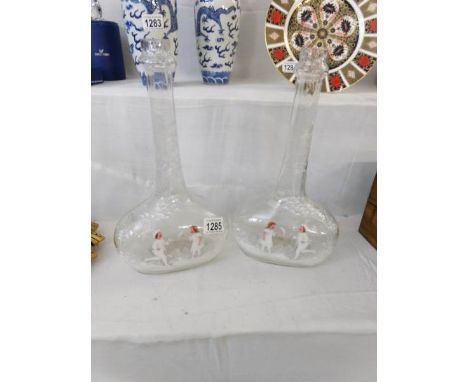 A fine pair of European Mary Gregory style bottles, clear glass painted on both sides with a boy and girl playing (with paint