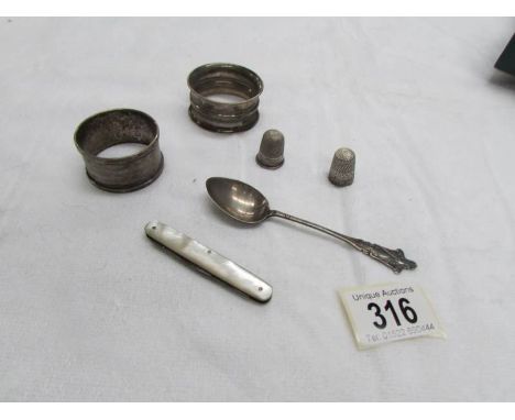 2 silver napkin rings, 2 silver thimbles, a silver spoon and a mother of pearl pen knife