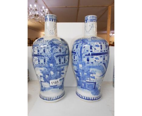 A large pair of rare shaped 19th century blue and white vases depicting a large house, stream and boats, having a 4 character