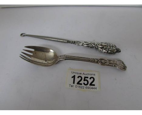 A silver cake spoon/fork and a silver handled button hook