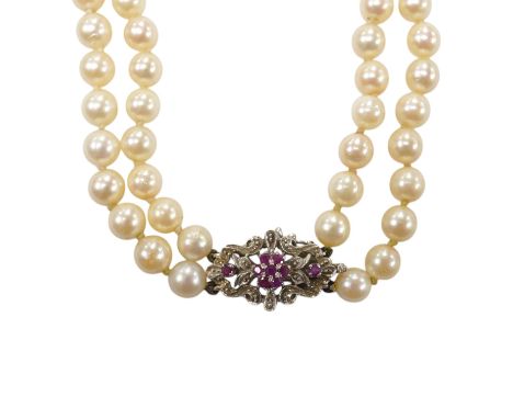 A modern double strand cultured pearl necklace, with ruby cluster set 750 white metal clasp. Condition - poor to fair