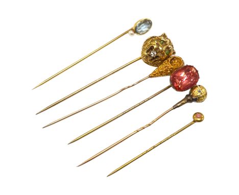 A collection of six assorted mainly early 20th century stick pins including tiger's head set with diamond and green garnets, 
