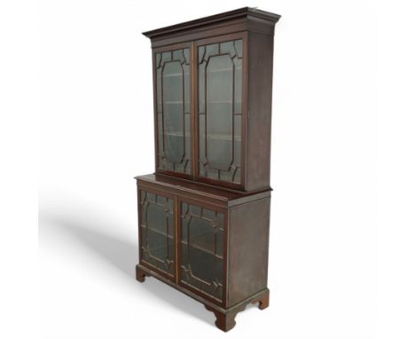 Early 20th century Chippendale design mahogany bookcase, projecting moulded cornice over four astragal glazed doors, the inte
