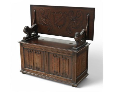 Late 20th century oak monk's bench, moulded rectangular hinged top carved with shield and scrolling foliage, hinged box stora