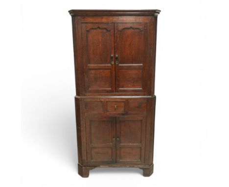 George III oak corner cupboard, moulded cornice over two panelled doors, stepped ogee arch upper panels, the lower section fi