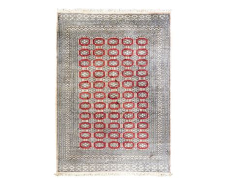 Jaldar Bokhara crimson and pale ground carpet, the field decorated with five rows of Gul motifs, within intricate multi-band 