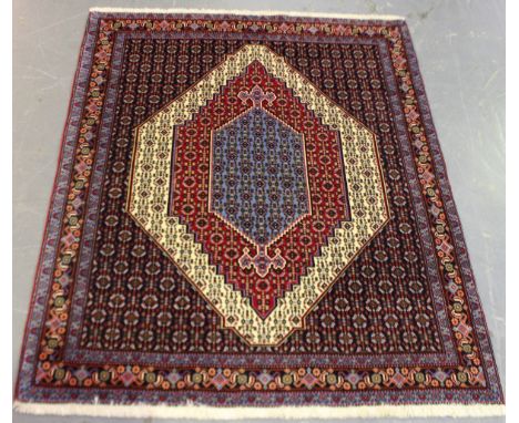 A fine Senneh rug, North-west Persia, late 20th century, the ivory field with a blue medallion and red reserve, within a palm