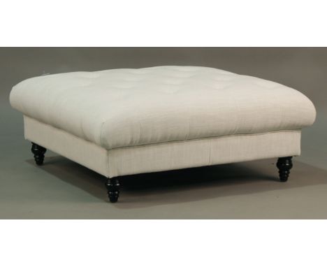 A modern footstool, upholstered in buttoned white fabric, on turned legs, height 40cm, width 103cm, depth 103cm.Buyer’s Premi