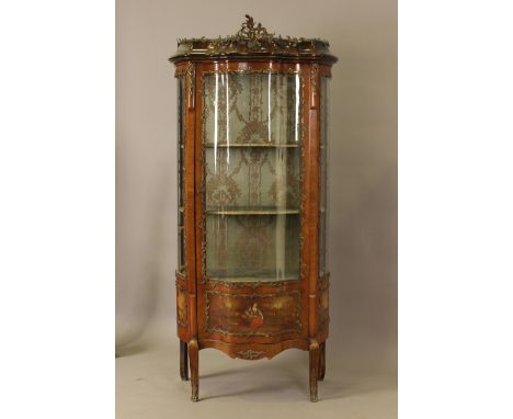 An early 20th century Louis XV style kingwood vitrine with overall gilt metal mounts, the glazed serpentine front with vernis