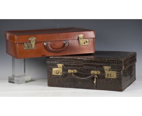 A crocodile skin suitcase, length 49cm (break to handle), together with a brown leather suitcase, length 50cm.Buyer’s Premium