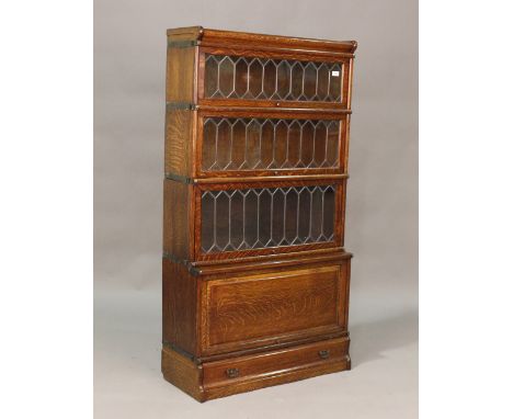 An early 20th century oak four-section Globe Wernicke bookcase, fitted with three leaded glass doors above a cupboard section