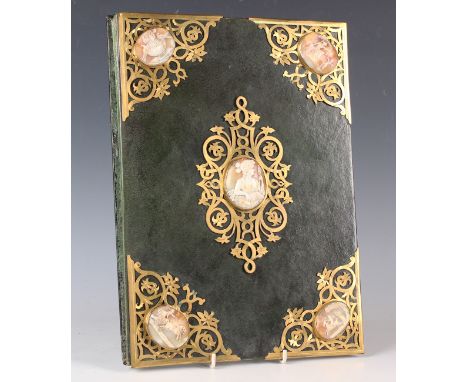 A 20th century leather and brass bound ink blotter, inset with five 19th century carved cameo shell mounts, 36cm x 26cm, and 