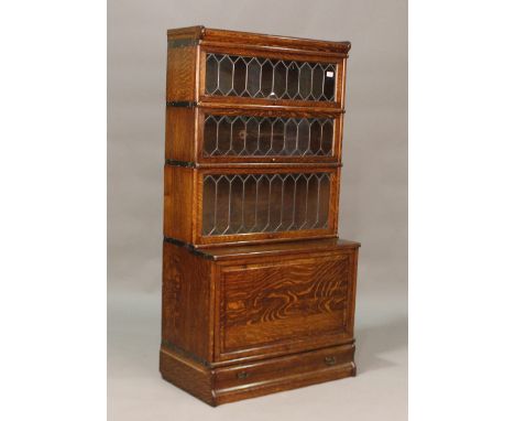 An early 20th century oak four-section Globe Wernicke bookcase, fitted with three leaded glass doors above a cupboard section