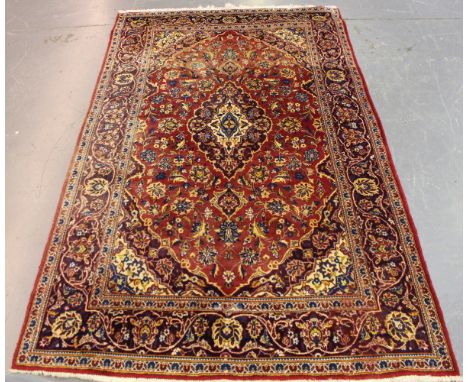 A Kashan rug, Central Persia, late 20th century, the red field with a shaped medallion, supported by curled leaves and palmet