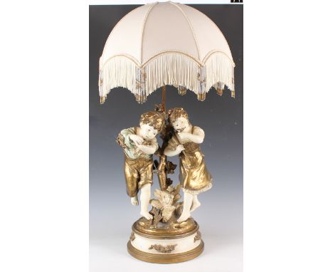 A 20th century cold painted cast metal figural table lamp, modelled as two children, together with shade, total height 85cm.B