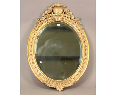 A good mid-Victorian oval gilt gesso framed wall mirror with shell, flower and leaf surmount above an egg and dart border and