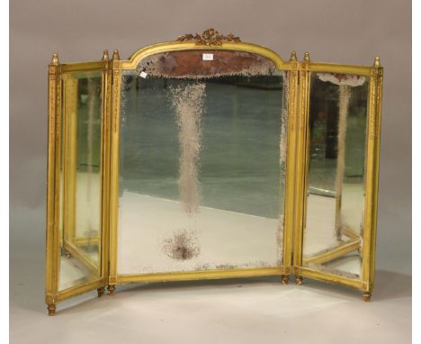 An Edwardian gilt composition triptych dressing table mirror, the central arched top with laurel leaf wreath, height 93cm, wi