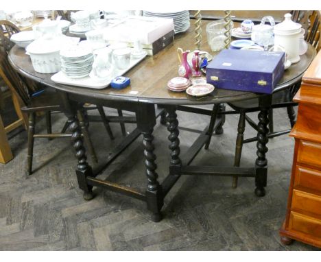 An oval oak gate legged dining table standing on barley twist legs, 3'6 wide 