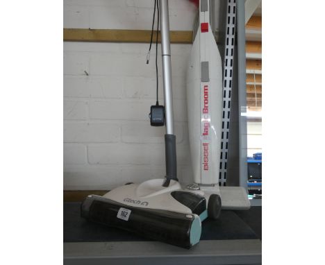 A GTech cordless upright vacuum cleaner and a Bissell magic electric broom 