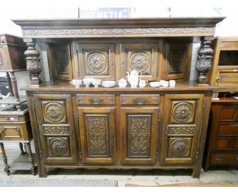A French heavily carved oak court cupboard style buffet with cupboard back, heavy carved pillars on two drawer on four cupboa