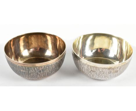 GERALD BENNEY CBE (1930-2008); a pair of circular silver bowls with textured bark effect detail, London 1968, each bowl furth